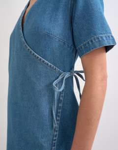 Model wearing Denim mini wrap dress in mid blue