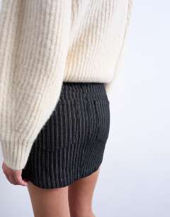 Model wearing Denim pelmet mini skirt in black stripe