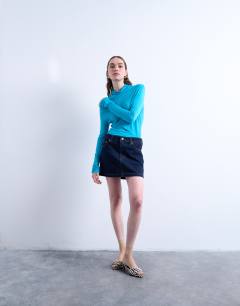 Model wearing Denim pelmet mini skirt in raw look indigo