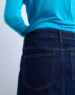 Model wearing Denim pelmet mini skirt in raw look indigo