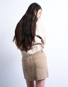 Model wearing Denim pelmet mini skirt in washed beige