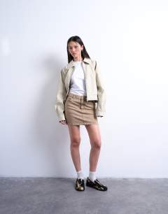 Model wearing Denim pelmet mini skirt in washed beige