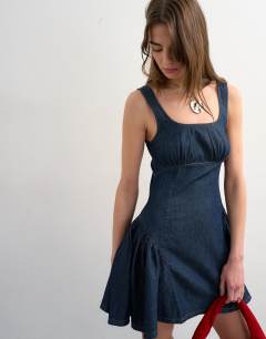 Model wearing Denim peplum hem mini dress in indigo rinse