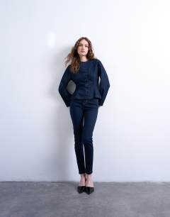 Model wearing Denim peplum long sleeve top in indigo