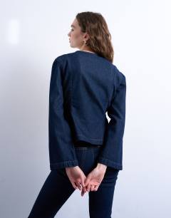 Model wearing Denim peplum long sleeve top in indigo