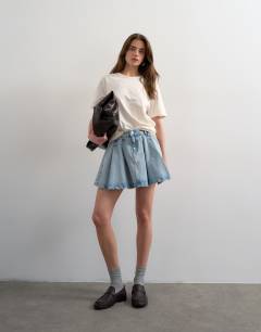 Model wearing Denim pleated full mini skirt in bleach