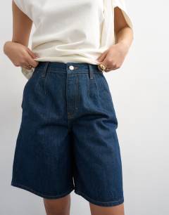 Model wearing Denim pleated longline short in indigo rinse