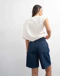 Model wearing Denim pleated longline short in indigo rinse