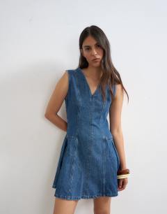 Model wearing Denim pleated side down mini dress rich blue