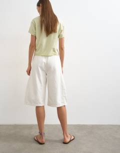 Model wearing Denim pull on barrel short in bone