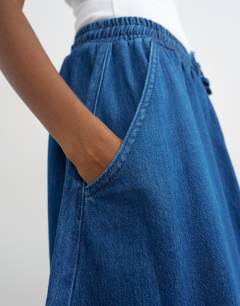 Model wearing Denim pull on barrel skirt in rich blue