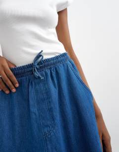 Model wearing Denim pull on barrel skirt in rich blue