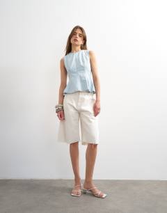 Model wearing Denim seamed peplum top in bleach