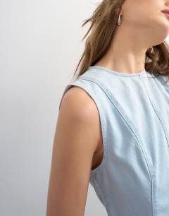 Model wearing Denim seamed peplum top in bleach