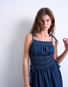 Model wearing Denim shirred maxi dress with straps in mid blue