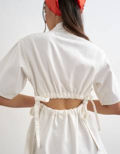 Model wearing Denim shirt dress with back cut out in white