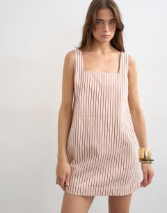 Model wearing Denim square neck pinny dress in ecru and red stripe