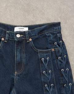 Model wearing Denim straight leg jean with extreme lace-up in deep blue