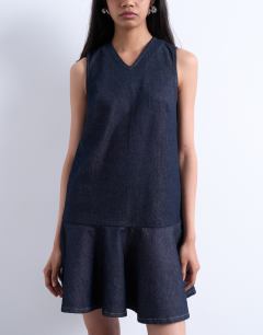 Model wearing Denim v neck peplum mini dress in indigo rinse