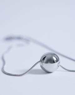 Model wearing Dolly waterproof necklace with ball in stainless silver