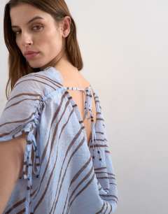 Model wearing Draped high neck top with tie in blue stripe