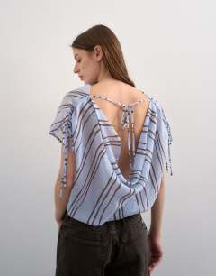 Model wearing Draped high neck top with tie in blue stripe