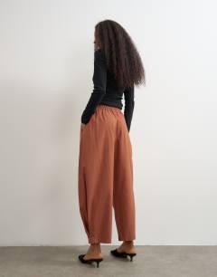 Model wearing Drawcord techy balloon trousers in rust