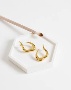 Model wearing Drew waterproof asymmetric hoop earring in gold