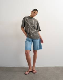 Model wearing Drop shoulder studio graphic print tee in washed black