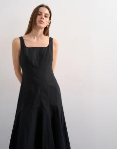 Model wearing Dropped hem full circle skirt sundress in black with contrast top stitch