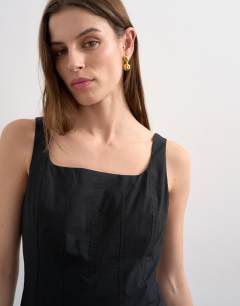 Model wearing Dropped hem full circle skirt sundress in black with contrast top stitch