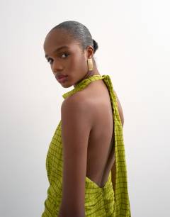 Model wearing Dropped waist halter maxi dress in brown and lime check