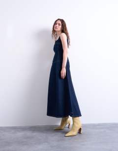 Model wearing Dropped waist structured denim midi dress in rinse