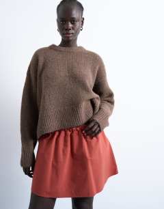 Model wearing Elasticated mini skirt in rust 