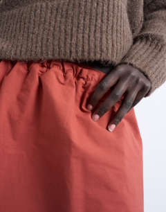 Model wearing Elasticated mini skirt in rust 