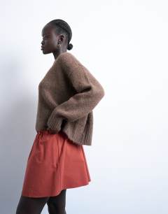 Model wearing Elasticated mini skirt in rust 