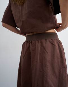 Model wearing Elasticated waist a-line woven maxi skirt in chocolate