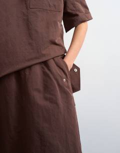Model wearing Elasticated waist woven maxi skirt in chocolate