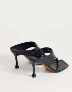 Model wearing Elodie toe thong mid heeled mule in black