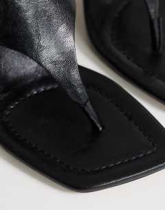 Model wearing Elodie toe thong mid heeled mule in black