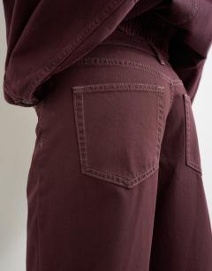 Model wearing Ember low rise relaxed straight jean in aubergine