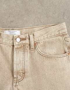 Model wearing Ember low rise relaxed straight leg jean in beige