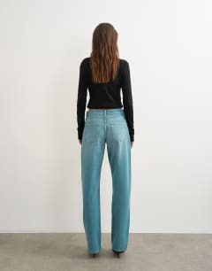 Model wearing Ember low rise relaxed straight leg jean in teal
