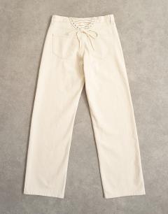 Model wearing Ember low rise relaxed straight leg jean with lace up detail in oat