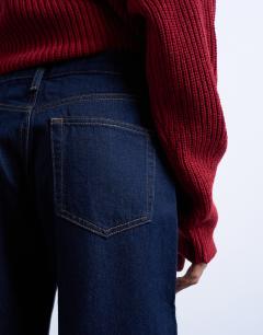 Model wearing Ember low rise straight leg jeans in indigo rinse