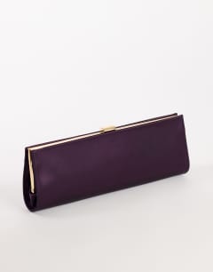 Model wearing Ember small envelope satin clutch bag in aubergine