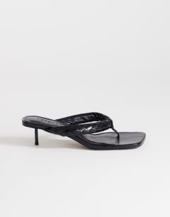Model wearing Emily pin heel woven toe thong sandal in black