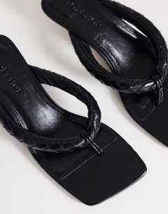 Model wearing Emily pin heel woven toe thong sandal in black