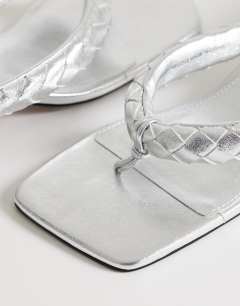 Model wearing Emily pin mid heel woven toe thong sandal in silver