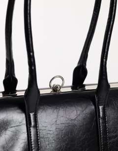 Model wearing Emma medium clasp shoulder bag in black
